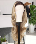 Front view of Royal Roots Boutique Miss Beyonce 26 inch premium human blend lace wig featuring voluminous honey blonde waves and an invisible melted hairline